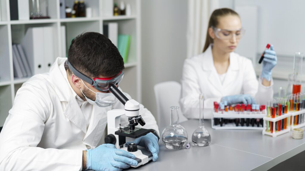 female-researcher-male-colleague-laboratory-with-test-tubes-safety-glasses